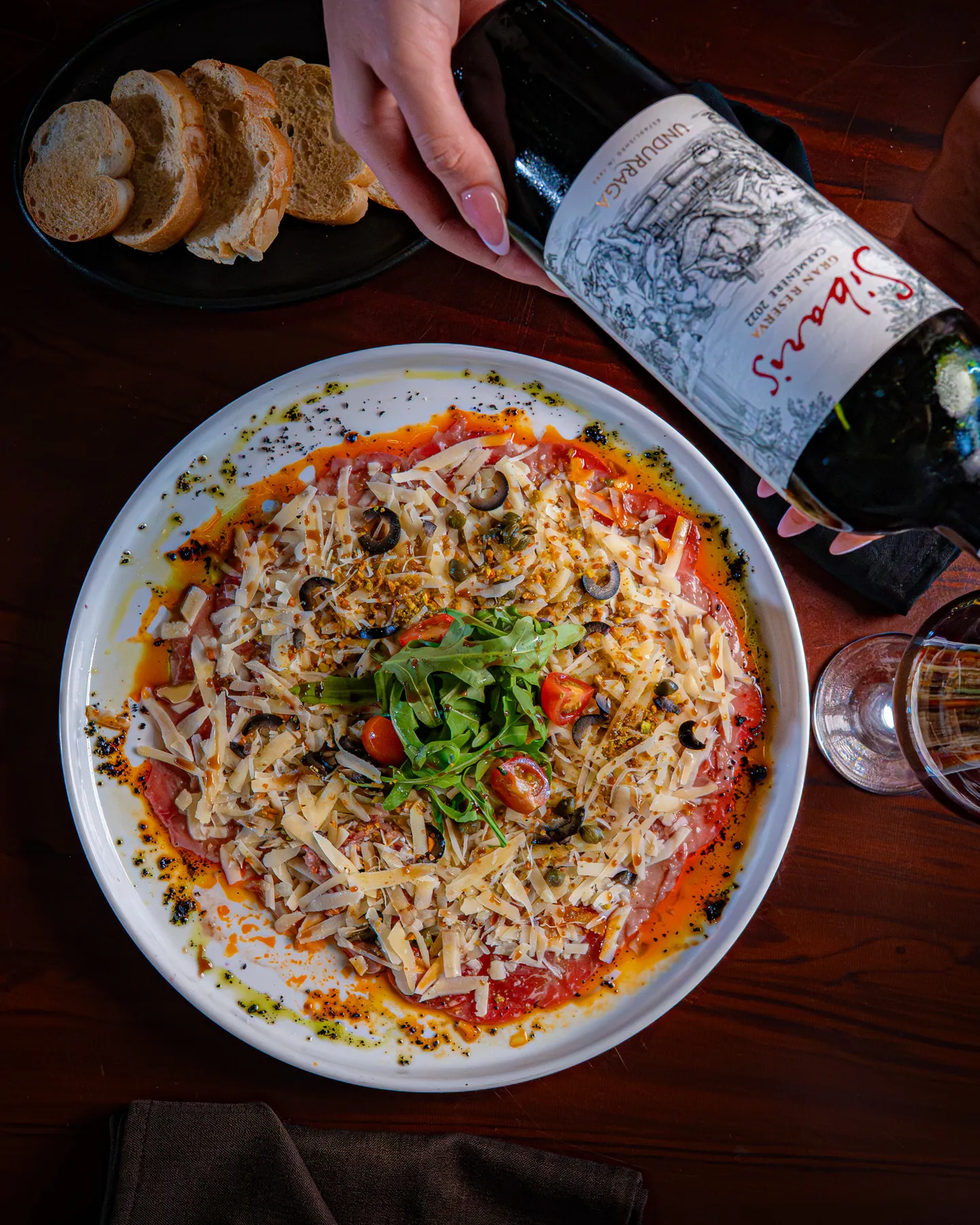 Carpaccio de res con parmesano, alcaparras y vino tinto, fotografiado por Vita Studio