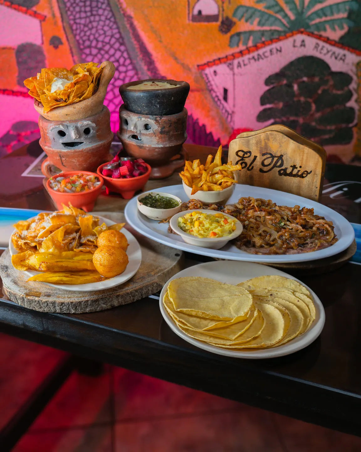 Mesa servida con anafres, tortillas, tajadas y carne asada, fotografiada por Vita Studio