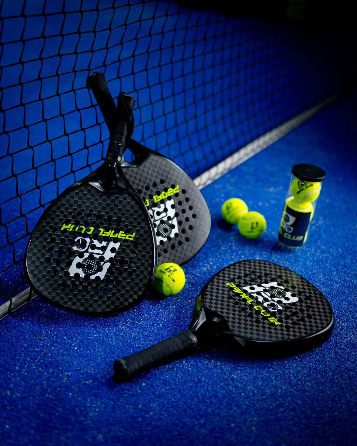 Palas y pelotas de pádel en cancha, fotografiadas por Vita Studio